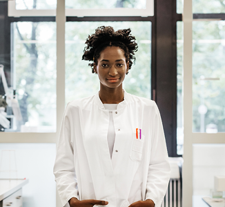 woman in a lab coat standing proudly