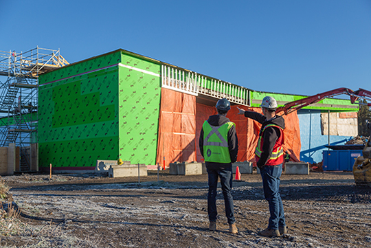 Two Chandos Construction employees looking at one of their construction sites