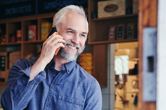 Man smiling and speaking on the phone
