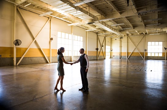 Two people shaking hands and closing a deal on a warehouse