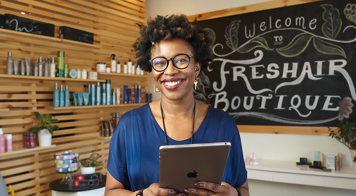 Owner of Freshair Boutique in front of a blackboard