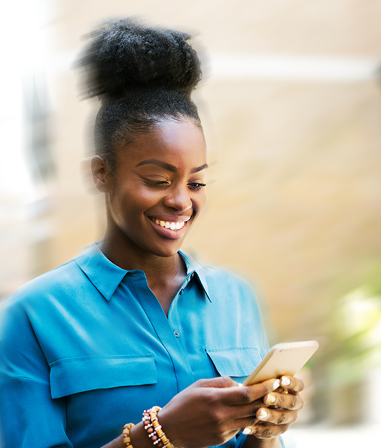 African-American woman consulting her cell phone while smiling