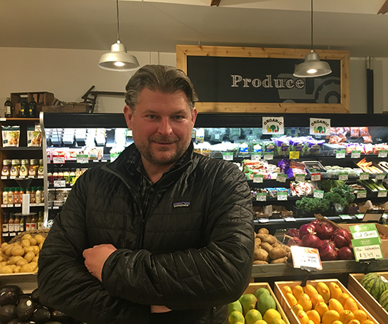 Ryan Smith - CEO of Great Greens Farm Market in front of produce