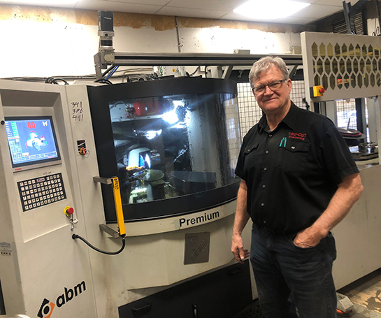 Lyle Brown, Co-owner of Tru-Cut Sharpening in front of a machine