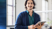 Outils pour financer votre entreprise bearded man wearing a blue cardigan holding a tablet in his studio office