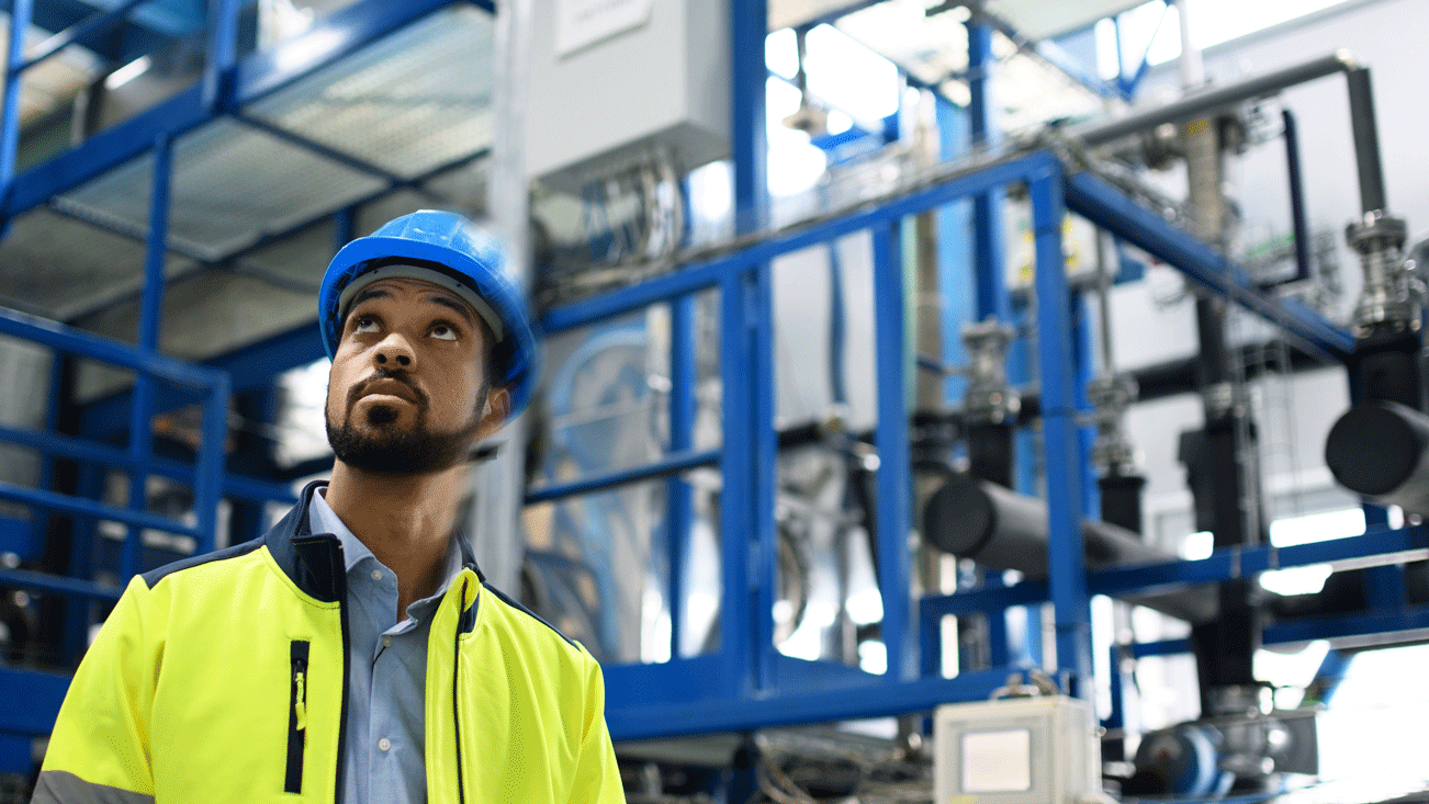 man in yellow vest working in a factory