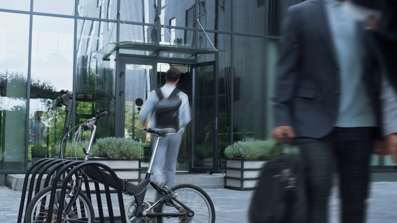 man parking his bike next to the office