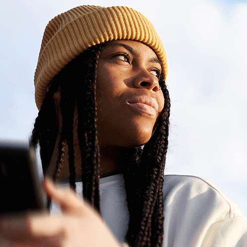 woman with yellow hat looking away, sky background