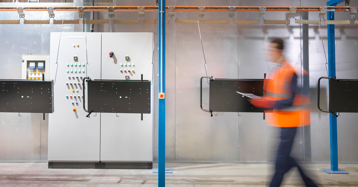 men walking in maintenance room in cement, with an orange jacket
