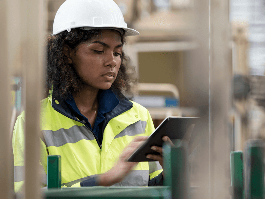 black women with white helmet and yellow jacket in an industry