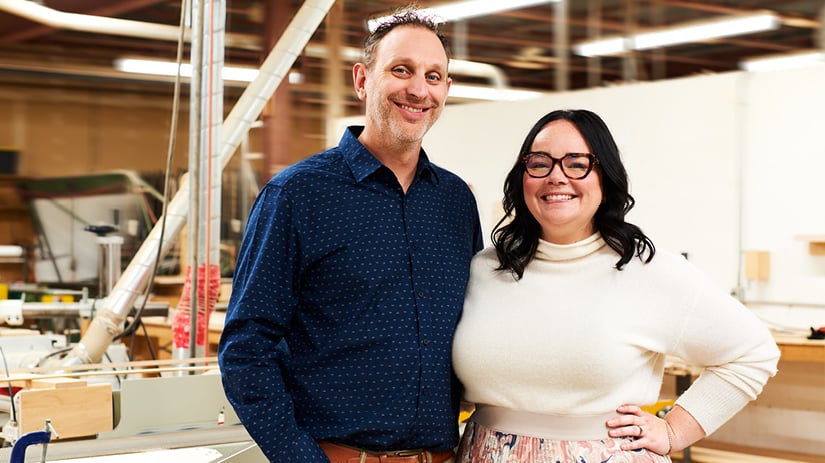 White Male-female couple posing in a wood workshop