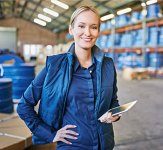 woman standing in a warehouse holding a tablet