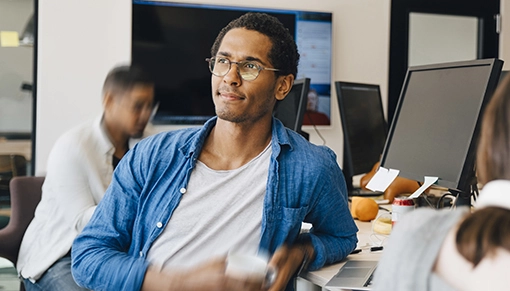 IT worker leaning on his desk with a coffee