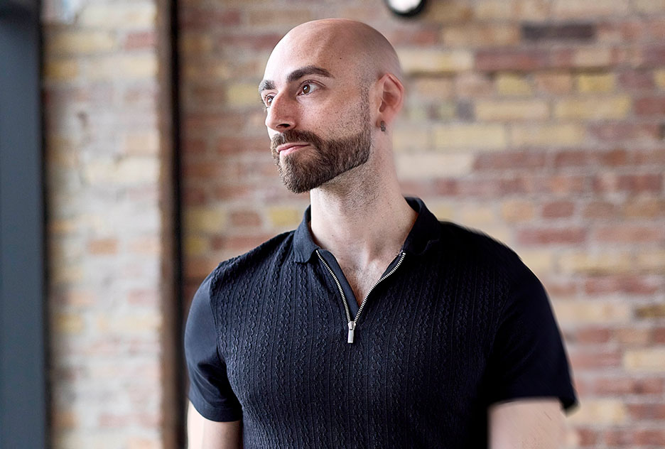 man looking away, black shirt, brick wall background