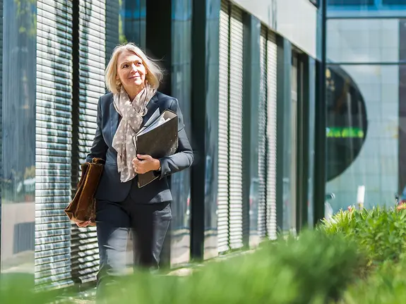 femme marchant à côté d’un bâtiment avec des plantes
