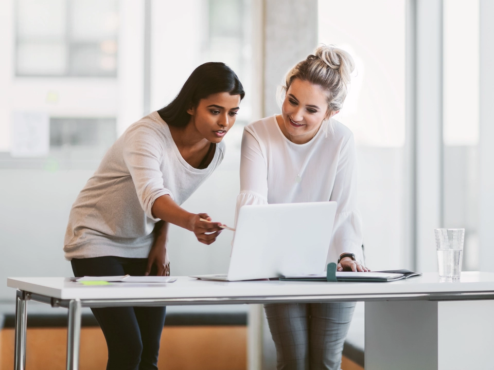 Two women in an office working on a computer