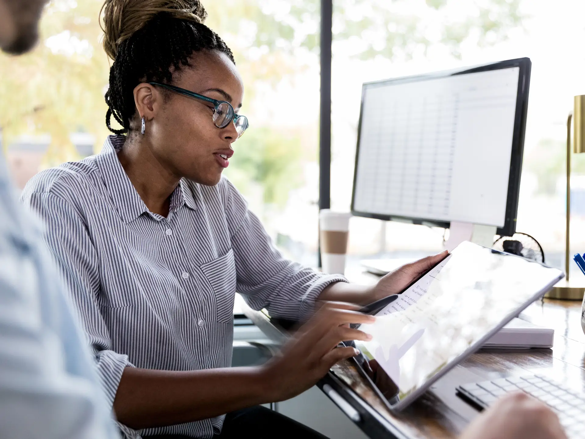 Un homme et une femme utilisent une tablette pour accomplir une tâche au bureau