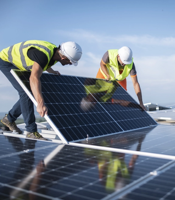 two men in hard hats doing maintenance on a solar panel