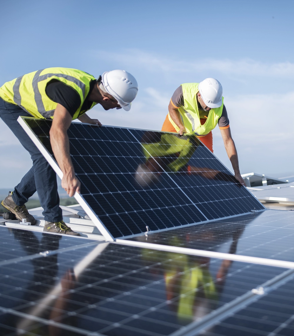 two men in hard hats doing maintenance on a solar panel