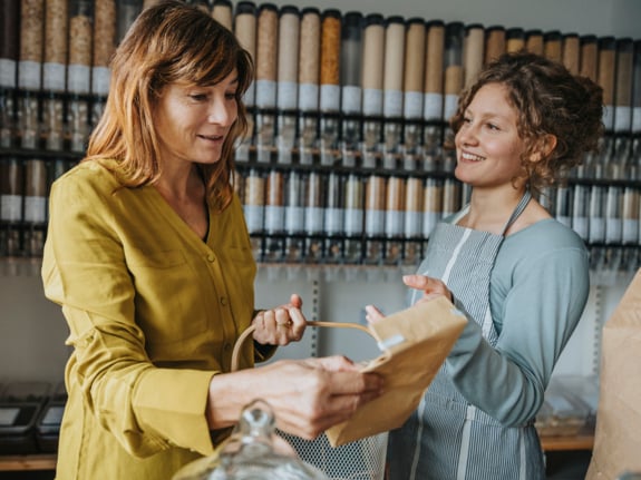 Commis de magasin parlant à un client mature lors de ses achats dans un magasin de détail