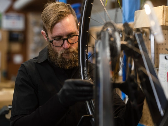 Employé portant des lunettes travaillant sur un vélo